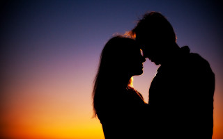 Sunset couple silhouette romantic backlighting - the sun setting behind them free wallpaper