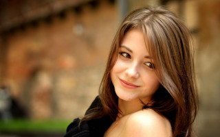 Woman smiling brick wall bokeh - a brick wall behind her free wallpaper