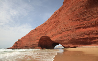 Large rock formation beach water - a large rock formation free wallpaper
