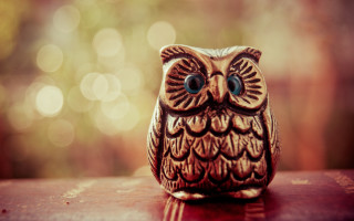 Small owl figurine blurry background - a blurry background of trees free wallpaper