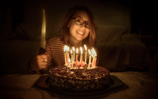 Woman holding knife cake lit - candle free wallpaper