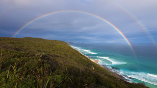 Rainbow beach cliff ocean cloudy - a rainbow in the middle free wallpaper