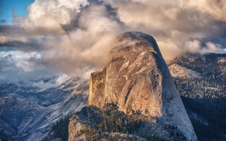 Mountain rockface clouds forest evening - a forest below free wallpaper