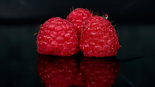 Three raspberries black surface reflection - food photography free wallpaper for desktop