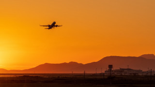 Sunset plane mountains building city - a plane free wallpaper for desktop