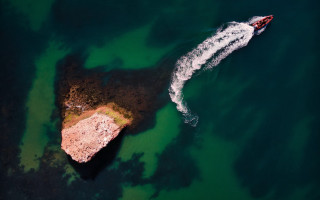 Boat rocks ocean tiltshift aerial - free beach wallpaper