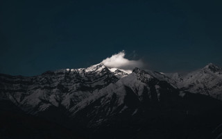 Snowy mountain range dark sky - free winter wallpaper