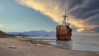 Ship beach ocean mountains clouds - the ocean under a cloudy sky free wallpaper