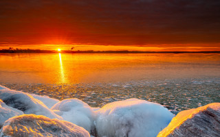 Sunset water ice rocks boat - the foreground and a boat in the distance free wallpaper