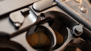 Gun black handle yellow dot - a close up of a gun free wallpaper