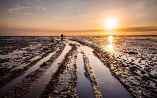 Beach sunset reflection mountains cityscape - the sun in the distance free wallpaper