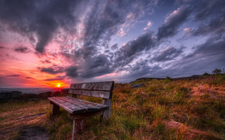 Bench hillside grass sunset cloudy - top of a grass free wallpaper