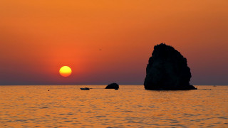 Sunset mountain ocean boat rock - a rock in the middle of it free wallpaper