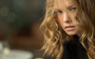 Blonde woman serious bokeh portrait - her face and shoulder free wallpaper