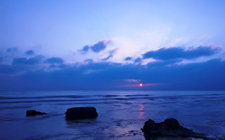 Sunset ocean rocks cloudy sky - a sun setting free wallpaper