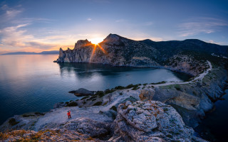 Cliff overlooking water mountains sunset - a body of water and mountains free wallpaper