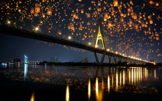Bridge lanterns cityscape night fireflies - a city skyline in the background free wallpaper