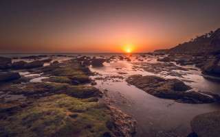 Sunset rocky beach city lights - a rocky shore line free wallpaper