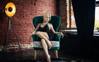 Woman tattoo chair brick wall - her arm and legs free wallpaper