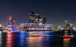 City skyline river bridge night 14 - the water and a boat in the foreground free wallpaper