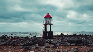 Lighthouse rocky beach cloudy sky - alexander jansson free wallpaper