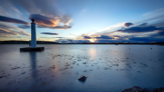 Lighthouse beach sunset cloudy sky - a sandy beach under a cloudy sky free wallpaper