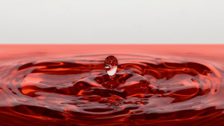 Red liquid droplet 3d render - a white wall in the background free wallpaper
