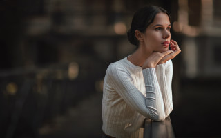 Woman leaning railing serious bokeh - her face free wallpaper