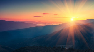 Sunset mountain range sunshine trees - a sunset over a mountain range free wallpaper