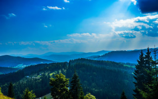 Mountain sunbeam trees forest lake - a scenic view of a mountain range free wallpaper