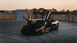 Black sports car doors open - a city skyline in the background free wallpaper