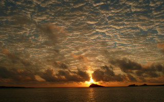 Sunset water clouds island cityscape - a small island in the distance free wallpaper