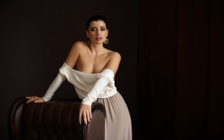 Woman white top brown chair - a black backdrop free wallpaper