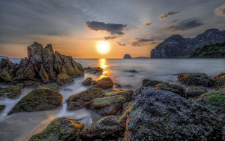 Sunset rocky beach mountain water 2 - a sun setting free wallpaper