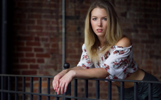 Woman fence portrait blonde blue - a brick wall behind her free wallpaper