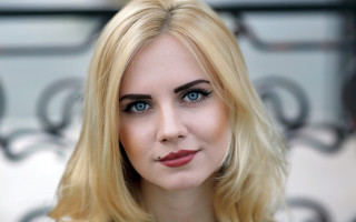 Blonde blue eyed woman portrait 4 - a wall behind her free wallpaper