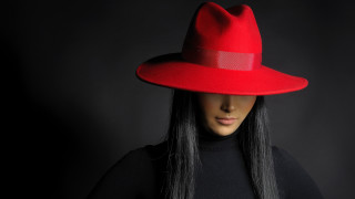 Woman red hat black background - a black background behind her free wallpaper for desktop
