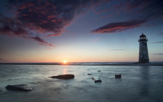 Lighthouse beach sunset rocks water - the foreground and a body of water free wallpaper for desktop