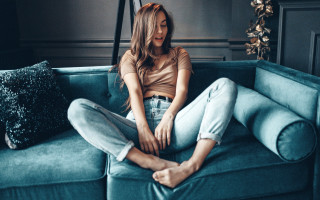 Woman sitting couch barefoot jeans - her foot free wallpaper