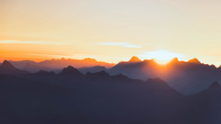 Sunset mountain range plane clouds 3 - a sunset over a mountain range free wallpaper
