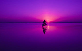 Person riding bike purple sunset - mystical color free wallpaper