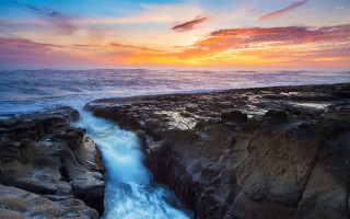 Sunset rocky beach waterfall ocean - over the water free wallpaper