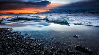 Sunset rocky beach icebergs water - free beach wallpaper