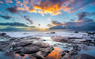 Sunset rocky beach reflection cityscape - a sunset over a rocky beach free wallpaper for desktop