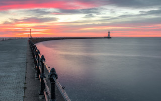 Sunset pier lighthouse water mountains - rich moody colour free wallpaper