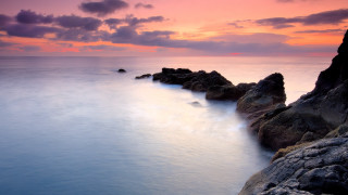 Sunset ocean rocks pink sky 3 - a pink sky in the background free wallpaper for desktop