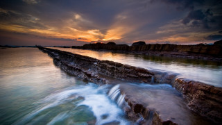 Sunset water rocks boat city - the foreground and a body of water free wallpaper for desktop