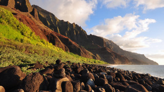 Rocky beach mountain water foreground - a mountain in the background and a body of water free wallpaper