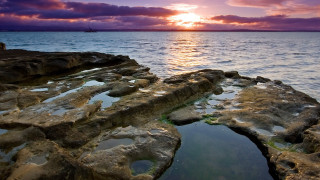 Rock formation water sunset clouds - a rock formation free wallpaper