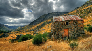 Small stone building mountains cloudy - free halloween wallpaper